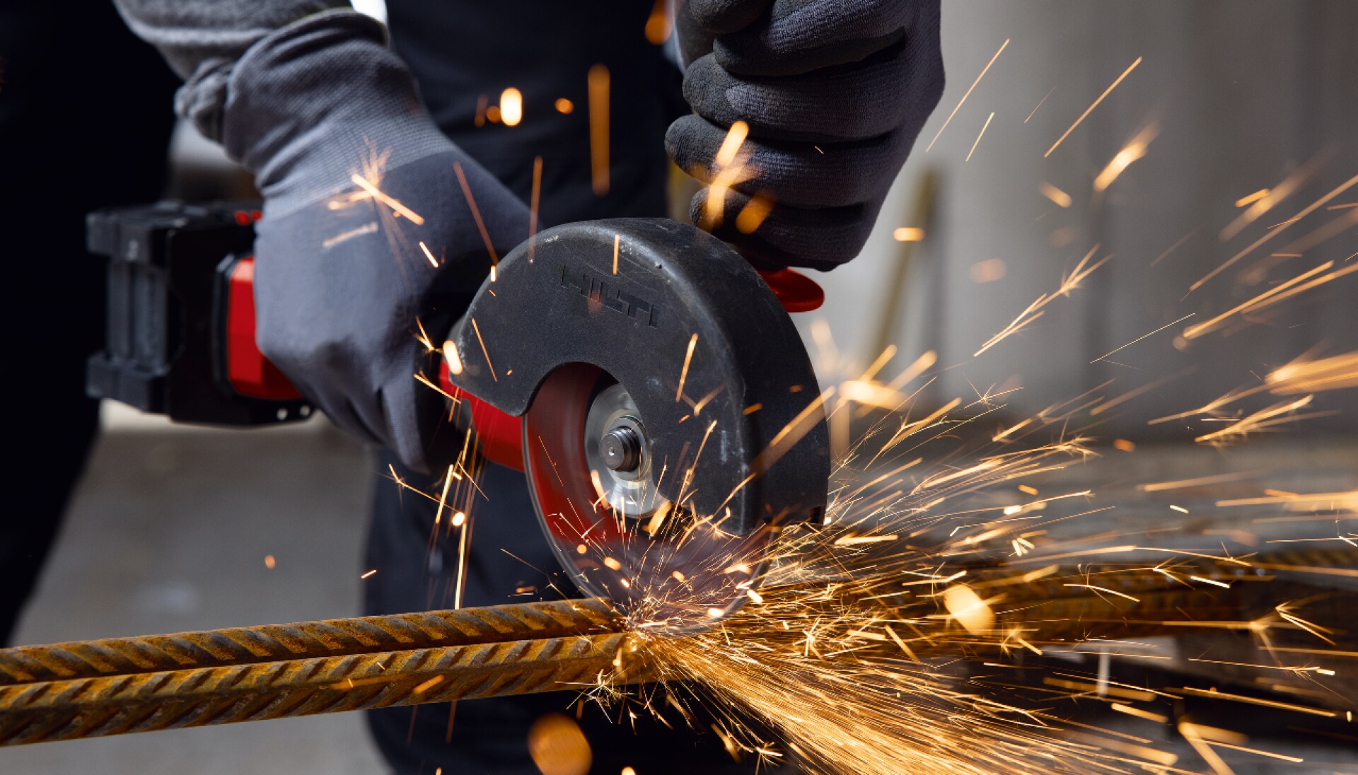 Worker cutting a rebar with an Angle Grinder causing sparks